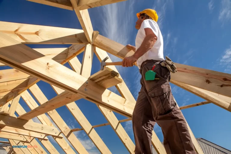 Un charpentier travaillant sur une charpente de maison.