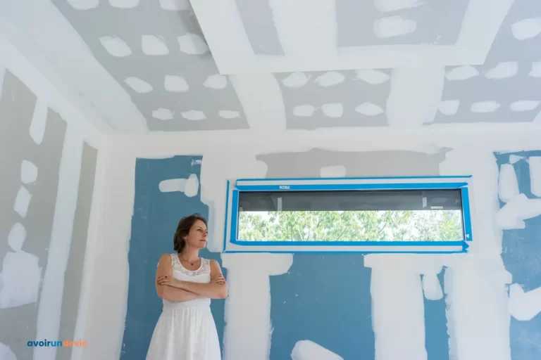 Une femme devant des cloisons en placo.