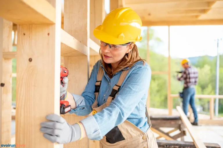 Ouvrière sur un chantier de construction pendant les travaux sur une maison à ossature en bois.