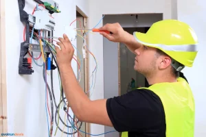 Un électricien travaillant sur un tableau de protection électrique
