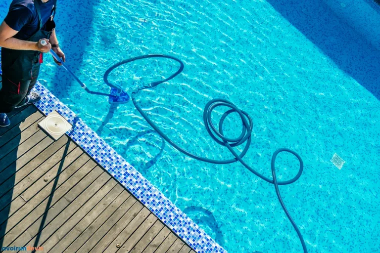 Homme nettoyant la piscine avec un équipement d'aspiration