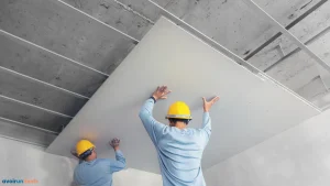 Deux artisans posant un faux plafond