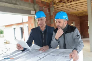 Un architecte et un entrepreneur vérifient les plans sur un chantier de construction.