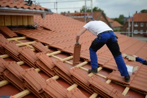 Un couvreur plaçant des tuiles sur une toiture